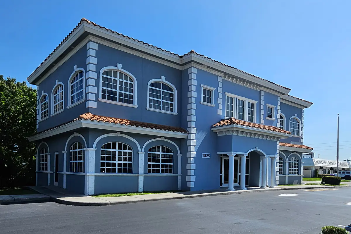 The Law Offices of Wolf & Pravato building at 1825 Colonial Boulevard in Fort Myers, a two-story blue building with a tile roof and arched windows