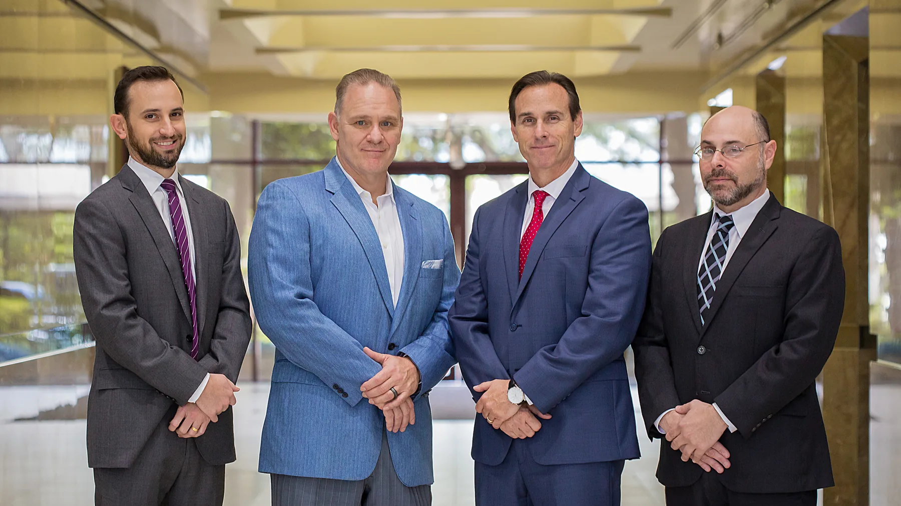 Attorneys Brett J. Yonon, Richard P. Pravato and Brian H. Malamud of Wolf & Pravato, with founding and managing partner Vince J. Pravato, in the lobby of their Fort Lauderdale office